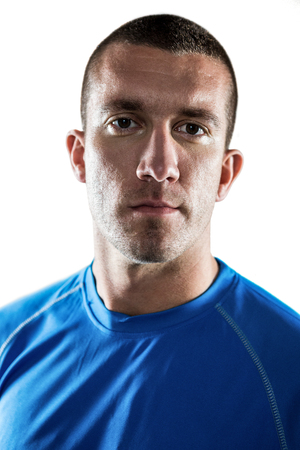 Close-up portrait of confident rugby player standing against white backgroundの写真素材