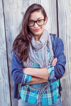 Happy hipster posing for a picture against a wooden wallの写真素材