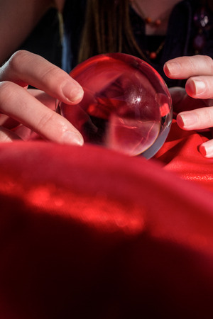 Fortune teller using crystal ball on red silkの写真素材