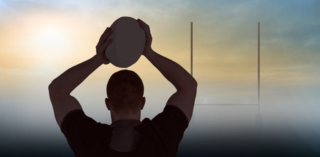 Rugby player about to throw a rugby ball against goals postsの写真素材