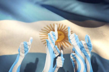 Hands up and thumbs raised against argentina flag against white backgroundの写真素材