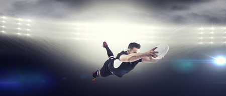 Rugby player scoring a try against spotlightの写真素材