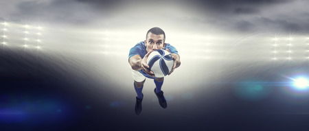 Portrait full length of American football player diving against spotlightの写真素材