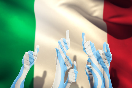 Hands up and thumbs raised against italy flag against white backgroundの写真素材