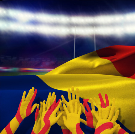 People raising hands in the air against rugby stadiumの写真素材