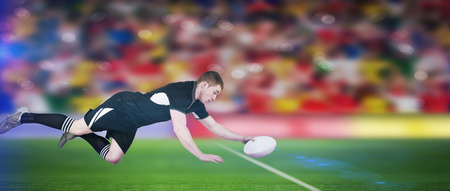 A rugby player scoring a try against rugby stadiumの写真素材