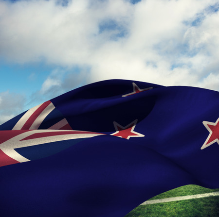 Waving flag of New Zealand against blue sky with cloudsの写真素材