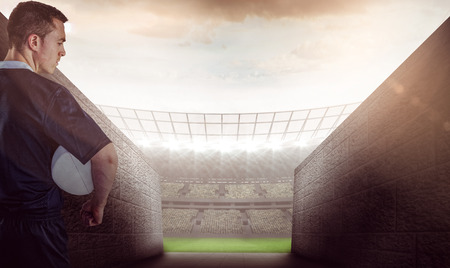 Rugby player gesturing with hands against rugby stadiumの写真素材