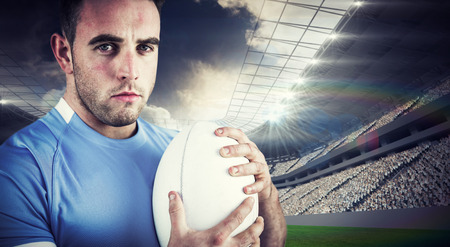 Rugby player looking at camera against rugby stadiumの写真素材