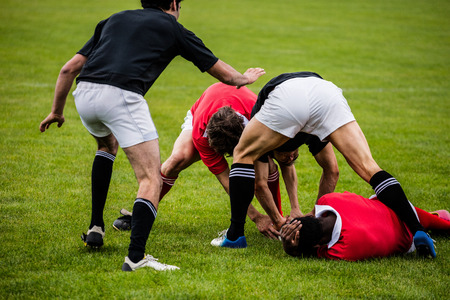 Rugby players tackling during game at the parkの写真素材