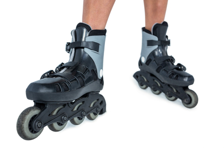 Low section of woman inline skating on white background