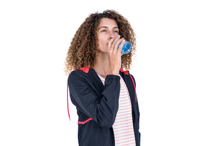 Young woman drinking water against white background