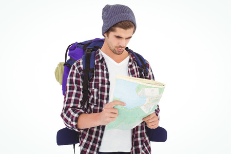 Man with luggage looking in map while standing against white backgroundの写真素材