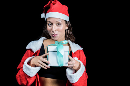 Portrait of athlete showing Christmas present against black backgroundの写真素材