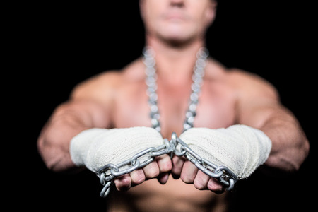 Man wearing bandage and chain against black background