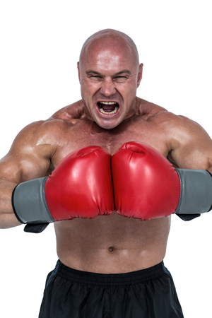 Aggressive fighter flexing muscles in gloves against white backgroundの写真素材
