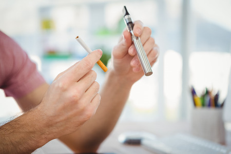 Cropped image of man holding cigarettes in office