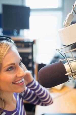 Close-up of female radio host broadcasting in studioの写真素材