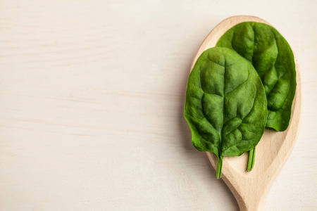 Portion cup of basil leaves on wooden tableの写真素材