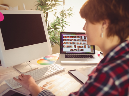 Graphic designer working at his computer in officeの写真素材