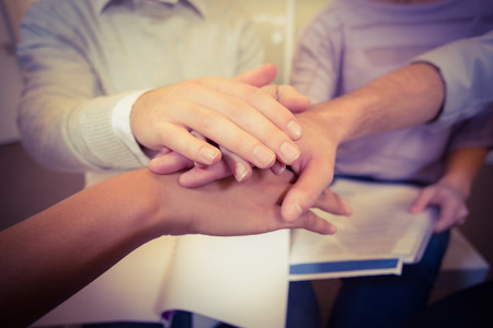 Close-up of business people with hand stack in meeting at creative office