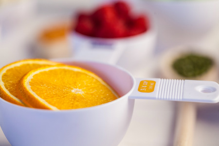 Portion cup of orange slices on wooden tableの写真素材