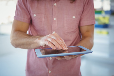 Mid section of hipster using digital tablet in officeの写真素材