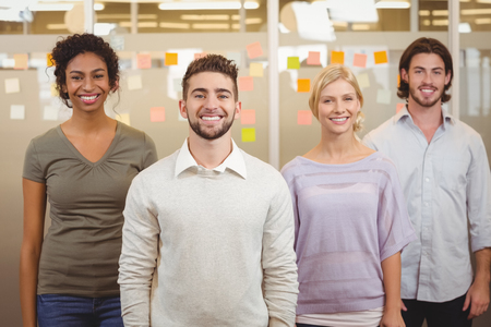 Portrait of happy colleagues standing together in creativie office