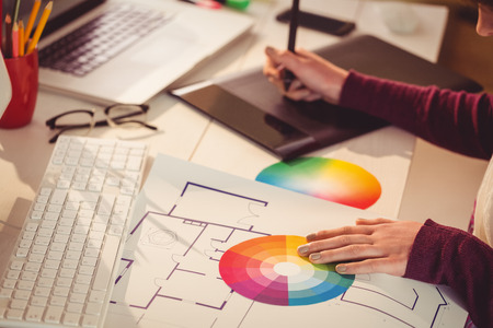 Graphic designer working at desk in officeの写真素材