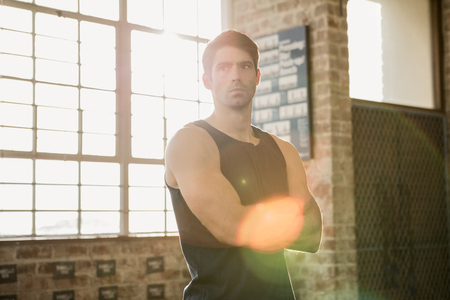 Serious man with arms crossed at the gymの写真素材