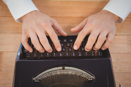 High angle view of man working on typewriter at table in officeの写真素材