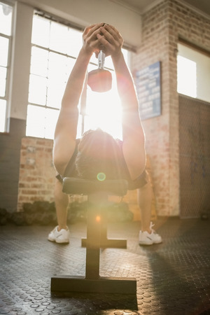 Man lifting dumbbell while lying on the bench at the gymの写真素材