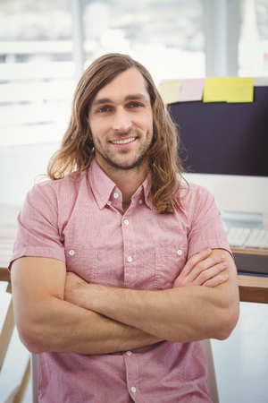 Portrait of confident hipster at computer desk in officeの写真素材