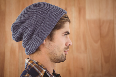 Profile view of confident hipster against wooden wall in officeの写真素材