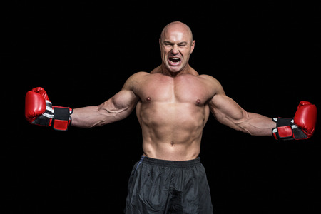 Successful boxer with arms outstretched against black backgroundの写真素材
