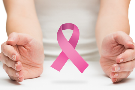 Hands presenting  against pink breast cancer awareness ribbonの写真素材