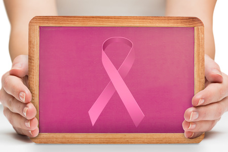 Females hands showing pink board against breast cancer awareness messageの写真素材