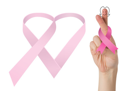Crossed fingers with breast cancer ribbon against breast cancer awareness messageの写真素材