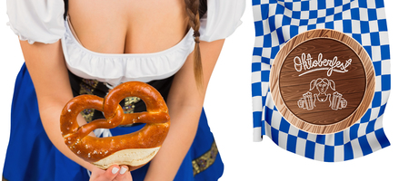 Oktoberfest girl bending and showing pretzel against oktoberfest graphicsの写真素材