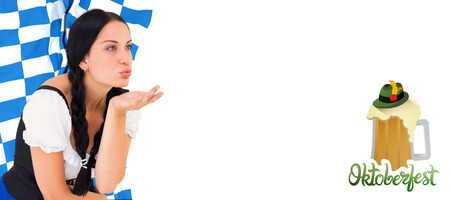Pretty oktoberfest girl blowing a kiss against oktoberfest graphicsの写真素材