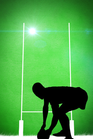 Silhouette of rugby player against green backgroundの写真素材