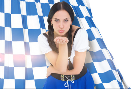 Pretty oktoberfest girl blowing a kiss against blue and white flagの写真素材