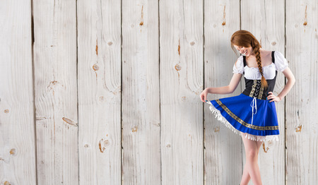 Oktoberfest girl spreading her skirt against wooden backgroundの写真素材
