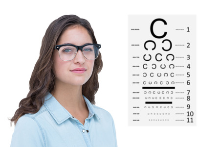 Pretty geeky hipster looking at camera against eye test