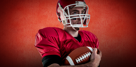 American football player being ready for playing against red backgroundの写真素材
