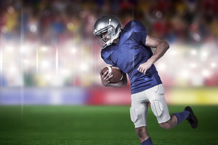 American football player holding ball in mid-air against rugby stadium
