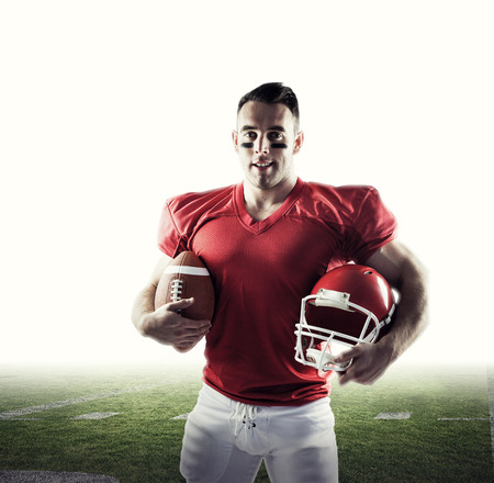 American football player looking at camera against american football pitch
