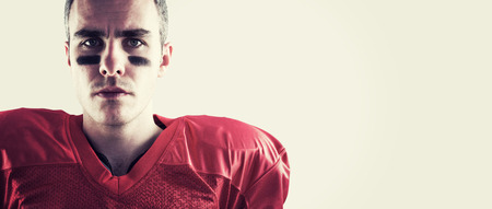 Portrait of a serious american football player looking at camera against white background with vignetteの写真素材
