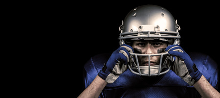 Portrait of American football player wearing helmet against blackの写真素材