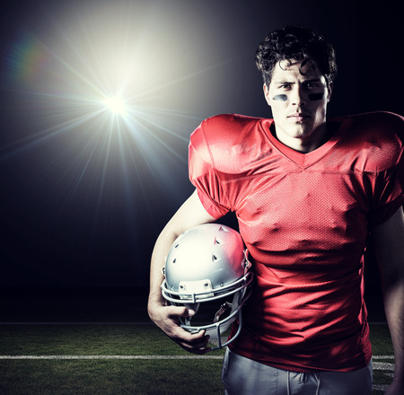 Portrait of determined sportsman holding helmet against blackの写真素材
